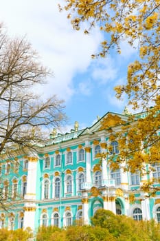 the incredibly picturesque facade of the Winter Palace through the branches of trees on a clear spring day, the heritage of Russia, the most famous landmark of St. Petersburg, the museum. High quality photo