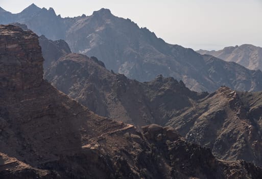 View from the top of the trail to the Monastery of rocky mountain range and gorges with desert in the distance