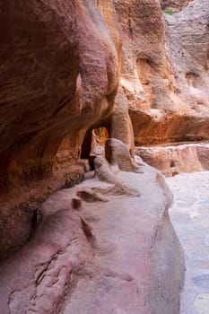 Carved water channels and pipes along the walls of the narrow gorge of the Siq entering Petra in Jordan