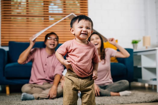 In their new home a loving family sits on the sofa holding a cardboard roof mockup representing security and joy during their home relocation. The answer is family togetherness and planning.