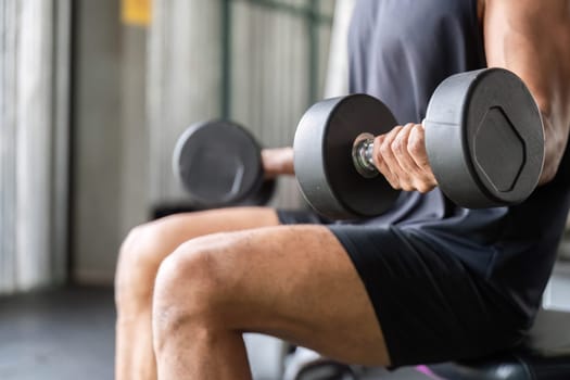 A male athlete performs a seated dumbbell exercise, emphasizing strength and fitness dedication.