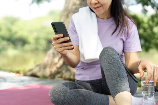A woman engages with her smartphone during a wellness break in nature, promoting mindfulness and relaxation.