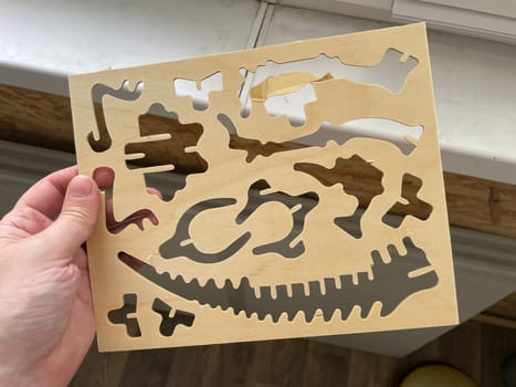 A handcrafted wooden dinosaur model displayed against a clean white background.