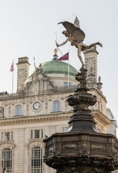 London, UK - May 13, 2025 - The Statue of Eros is The Greek god anteros (the Greek God of love)​ that sits atop of the Shaftesbury memorial fountain with Hotel cafe royal (County fire office of the quadrant) in the background. a cast aluminium sculpture with winged poised in Piccadilly circus. use it as your Wallpaper, Poster and Copy space, Selective focus.