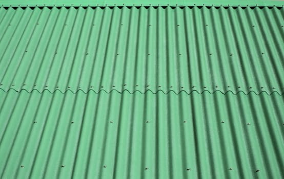 Green wave shaped metal siding, roofing material.