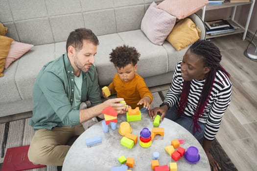 A family enjoys playtime together, building with vibrant blocks at home.