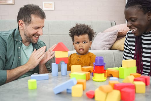 A family has fun playing with colorful building blocks together.