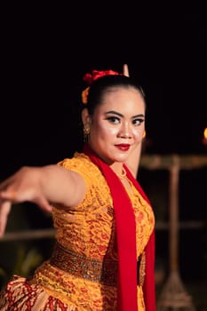 Sundanese woman with an exotic face wearing a yellow dress and red scarf during a dance exhibition at the festival