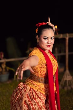 Sundanese woman with an exotic face wearing a yellow dress and red scarf during a dance exhibition at the festival