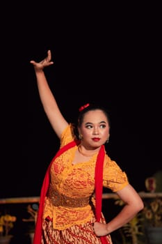 Indonesian women wearing traditional dance costumes called kebaya and pose with dancing moves in the night after the performance