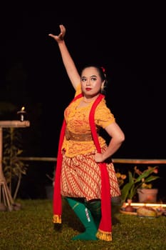 Indonesian women wearing traditional dance costumes called kebaya and pose with dancing moves in the night after the performance