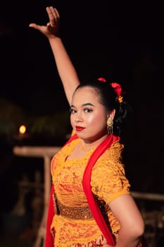 Indonesian women wearing traditional dance costumes called kebaya and pose with dancing moves in the night after the performance