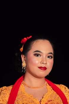 Sundanese woman wearing a short dress and traditional yellow dress with red scarf and makeup after the dance performance on the stage