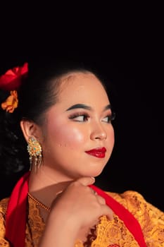 Beautiful face of an Asian woman with red lips and makeup in Indonesian traditional dance costume after the dance performance in the stage