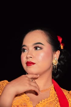 Beautiful face of an Asian woman with red lips and makeup in Indonesian traditional dance costume after the dance performance in the stage