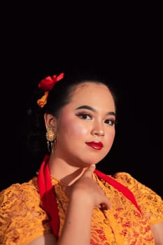 Beautiful face of an Asian woman with red lips and makeup in Indonesian traditional dance costume after the dance performance in the stage