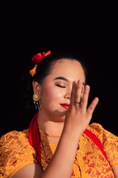 Beautiful face of an Asian woman with red lips and makeup in Indonesian traditional dance costume after the dance performance in the stage