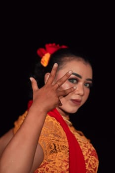 Sharp eyes from Indonesian women with makeup while wearing an orange dress at the dancing festival in the night