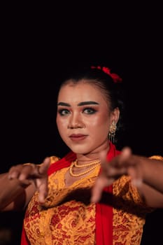 Sharp eyes from Indonesian women with makeup while wearing an orange dress at the dancing festival in the night