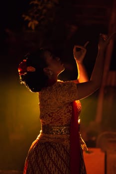 Balinese women wearing cultural clothes while posing in front of the lighting with dancing movements on their body