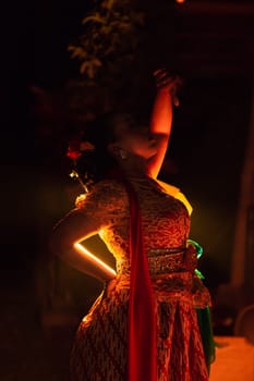 Balinese women wearing cultural clothes while posing in front of the lighting with dancing movements on their body