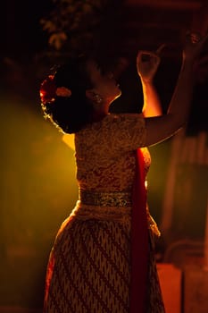 Balinese women wearing cultural clothes while posing in front of the lighting with dancing movements on their body