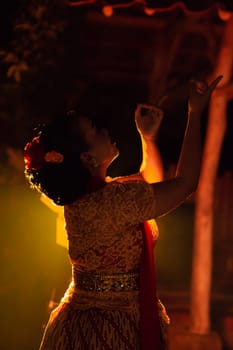 Balinese women wearing cultural clothes while posing in front of the lighting with dancing movements on their body