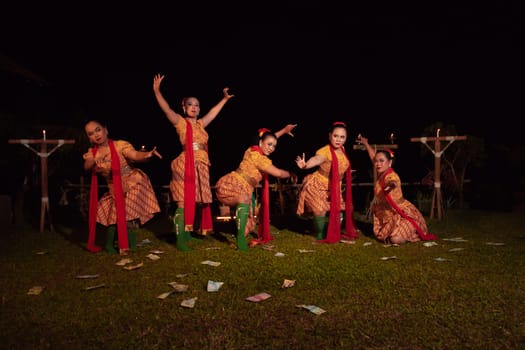 Javanese dancers with beautiful makeup and traditional costume while dancing the traditional dance on the stage inside the village show