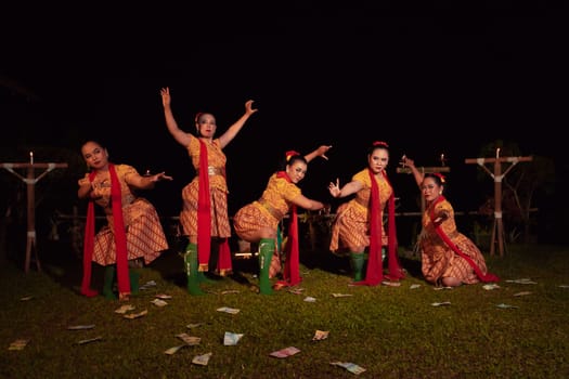 Javanese dancers with beautiful makeup and traditional costume while dancing the traditional dance on the stage inside the village show