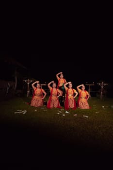Asian dancers take pose with dance movements while performing the traditional dance in the competition during the night
