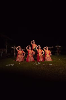 Asian dancers take pose with dance movements while performing the traditional dance in the competition during the night