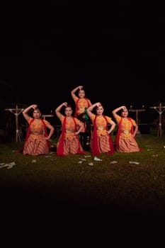 Asian dancers take pose with dance movements while performing the traditional dance in the competition during the night
