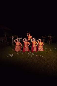 Asian dancers take pose with dance movements while performing the traditional dance in the competition during the night