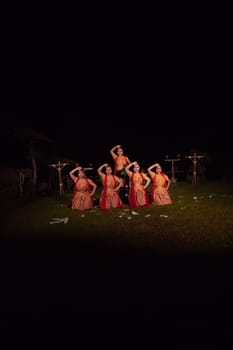 Asian dancers take pose with dance movements while performing the traditional dance in the competition during the night