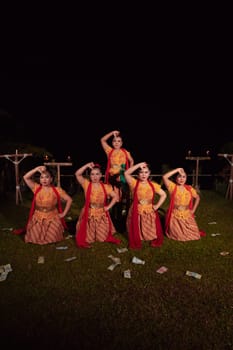Asian dancers take pose with dance movements while performing the traditional dance in the competition during the night