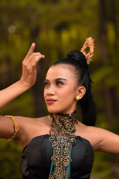 Portrait of a Balinese woman with beautiful makeup and tied black hair on a brave facial expression inside the jungle