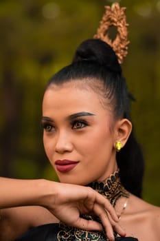 The fierce face of an Indonesian woman wearing makeup on her face and a black costume after a dance performance at the festival