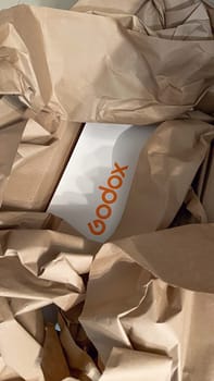 Ottawa, ON Canada - May 01, 2025: Unboxing of a Godox product, showcasing a white box with the Godox logo nestled in crumpled brown paper, highlighting the careful packaging