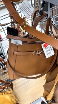 Ottawa, ON Canada - May 01, 2025: Stylish brown leather handbag by Michael Kors hanging on a display rack in a retail store, highlighting its elegant design and brand logo, ideal for fashion enthusiasts
