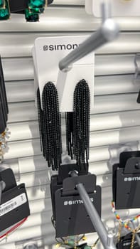 Ottawa, ON Canada - May 11, 2025: Elegant black beaded earrings are showcased on a white card featuring Simon's branding, highlighting intricate craftsmanship and stylish design in a retail environment