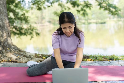 A woman engages in yoga exercises on a mat by the serene lakeside, promoting wellness and mindfulness in nature.