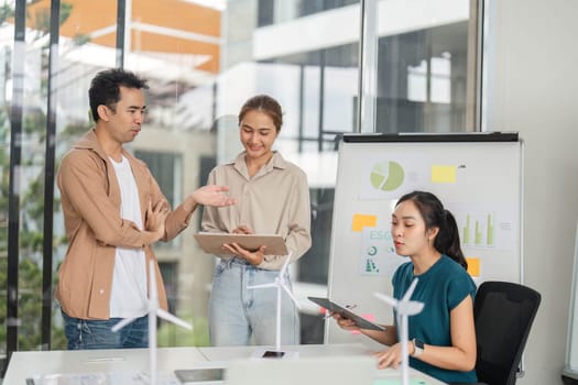 A diverse team discussing ESG strategies, showcasing graphs and data on sustainable business practices in a bright office.
