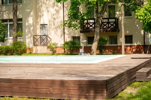 swimming pool design at modern residence.courtyard with green trees, lawn and hotel or multi-storey building in the background.