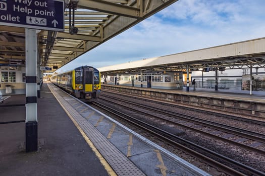 Surbiton train station showing platform, tracks, and a modern train ready for departure.