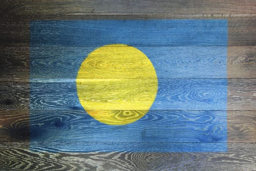 A Palau flag on rustic old wood surface background blue Pacific Ocean gold full moon