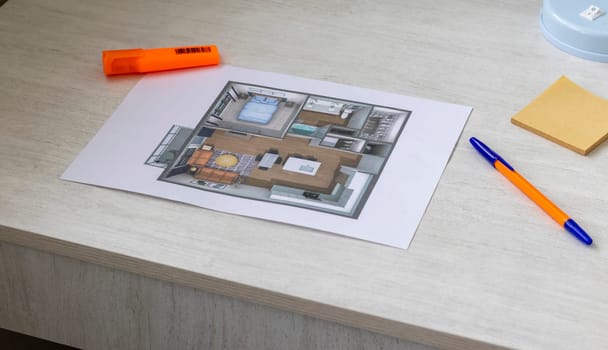 Layout of the small, furnished apartment printed on the sheet of paper placed on the desk