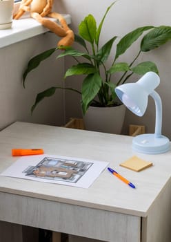Layout of the small, furnished apartment printed on the sheet of paper placed on the desk