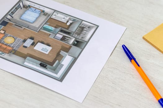 Layout of the small, furnished apartment printed on the sheet of paper placed on the desk
