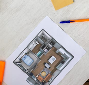 Layout of the small, furnished apartment printed on the sheet of paper placed on the desk