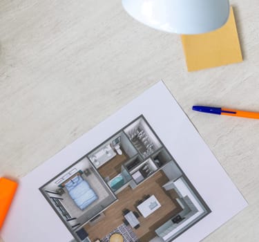 Layout of the small, furnished apartment printed on the sheet of paper placed on the desk